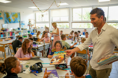 Photo de monsieur le Maire Arnaud Latil accompagné de Madame Laurence Meslard qui distribue les BD aux élèves de CM2 dans leur classe - Agrandir l'image, .PNG 1 Mo (fenêtre modale)