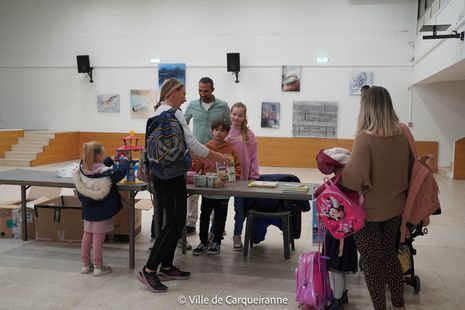 Stand de la collecte de dons tenu par le Conseil Municipal des Enfants en salle des fêtes de l'Hôtel de Ville avec des personnes qui viennent déposer leur dons - Agrandir l'image, .JPG 155 Ko (fenêtre modale)